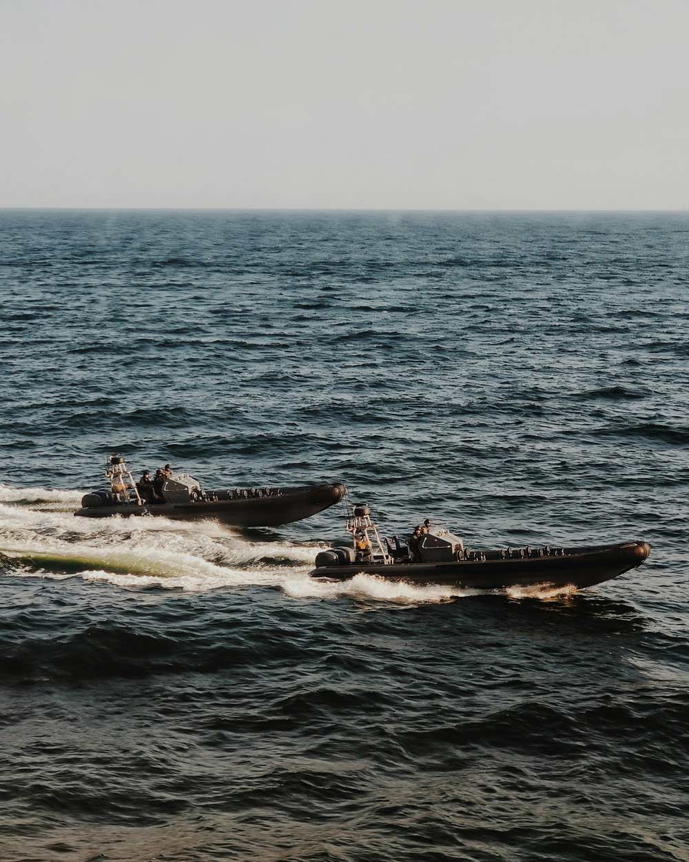 Two speedboats on the ocean with a clear sky