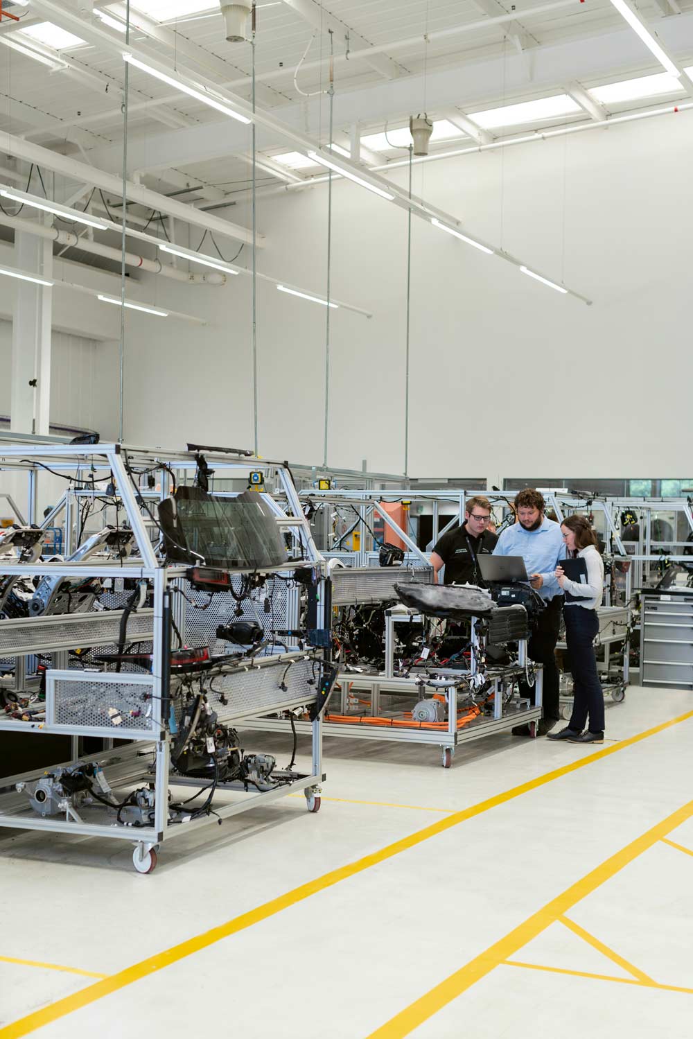 People working in a factory setting with machinery and equipment.